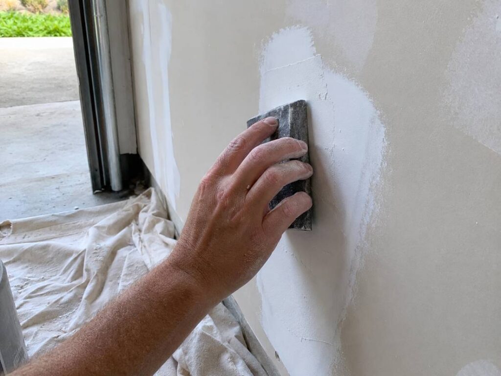 Painter preparing a garage wall before painting in New Jersey